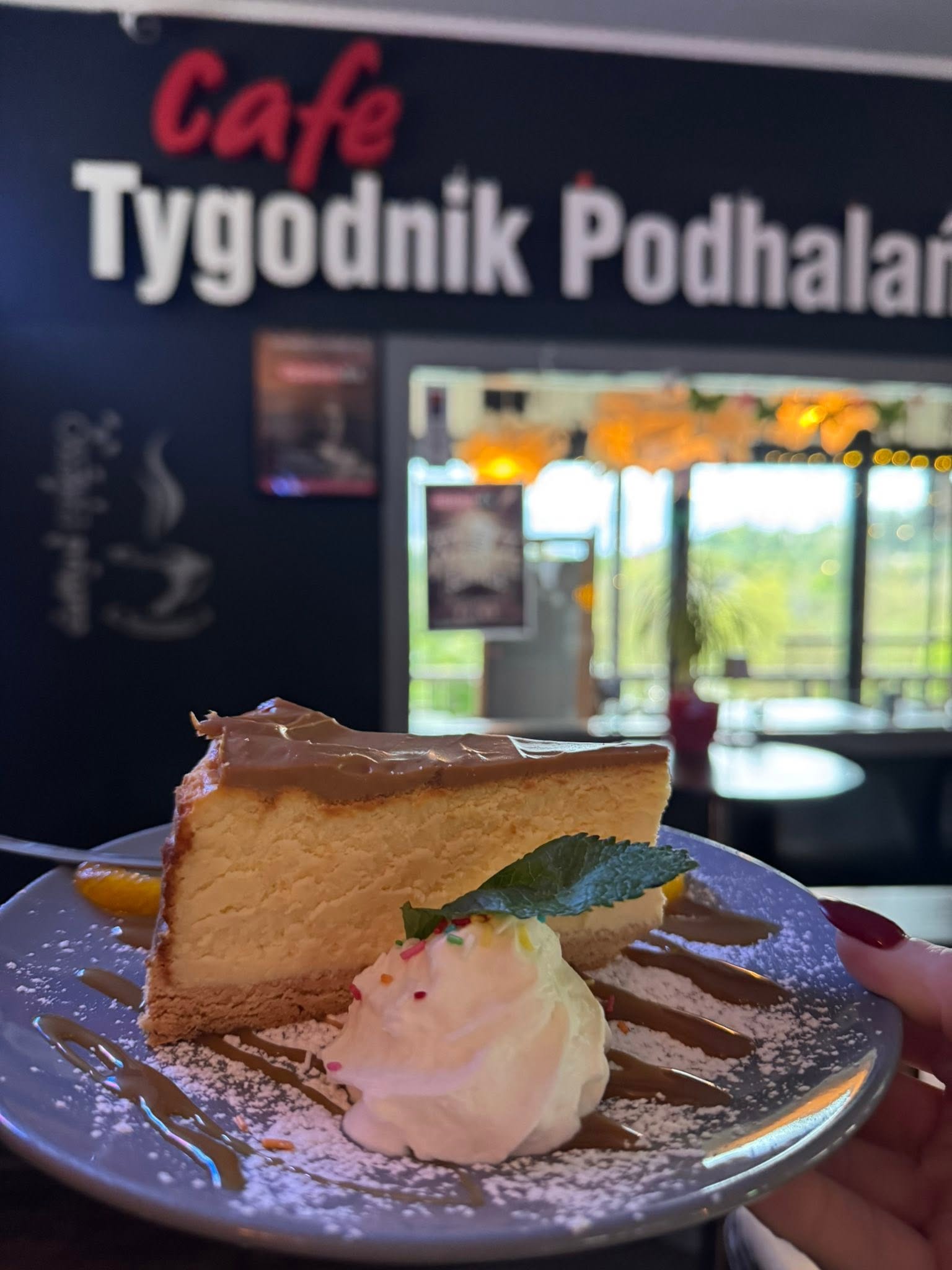Wnętrze Café Tygodnik Podhalański ze ścianami wyklejonymi stronami gazety